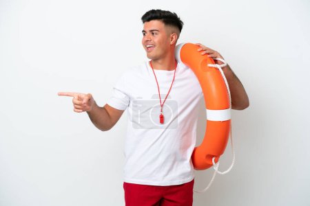 Téléchargez les photos : Jeune bel homme isolé sur fond blanc avec un équipement de sauveteur et un doigt pointant vers le côté - en image libre de droit