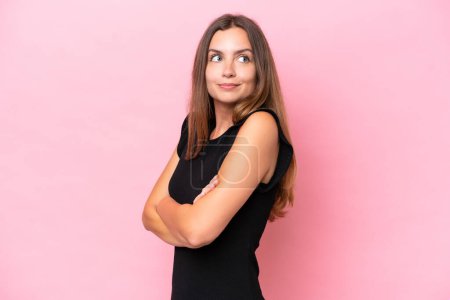 Téléchargez les photos : Jeune femme caucasienne isolée sur fond rose faisant des doutes geste tout en soulevant les épaules - en image libre de droit