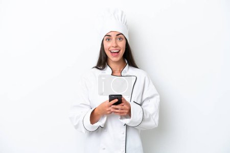 Photo for Young chef woman over white background surprised and sending a message - Royalty Free Image