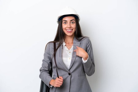 Photo for Young architect caucasian woman with helmet and holding blueprints isolated on white background with surprise facial expression - Royalty Free Image