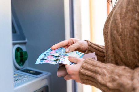 Photo for Young woman using an ATM - Royalty Free Image
