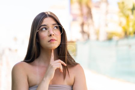 Foto de Joven mujer brasileña bonita al aire libre Con gafas y mirando hacia arriba - Imagen libre de derechos