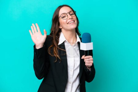 Photo for Young TV presenter woman isolated on blue background saluting with hand with happy expression - Royalty Free Image