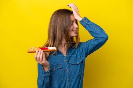 Foto de Joven mujer caucásica sosteniendo sashimi aislado sobre fondo amarillo se ha dado cuenta de algo y la intención de la solución - Imagen libre de derechos