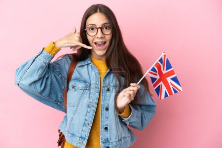 Téléchargez les photos : Jeune fille française tenant un drapeau du Royaume-Uni isolé sur fond rose faisant geste de téléphone. Rappelle-moi signe - en image libre de droit