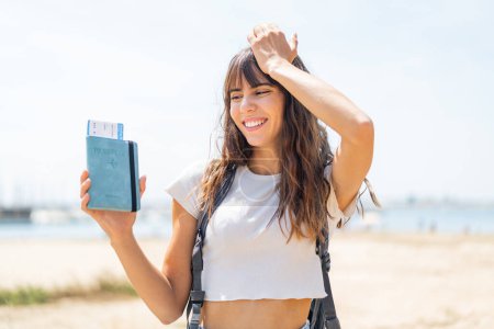Foto de Mujer joven sosteniendo un pasaporte al aire libre se ha dado cuenta de algo y la intención de la solución - Imagen libre de derechos