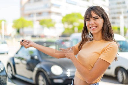Photo for Young woman at outdoors holding car keys with happy expression - Royalty Free Image
