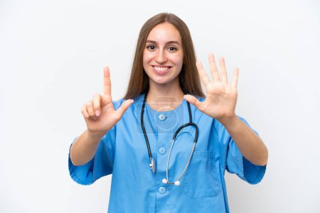 Téléchargez les photos : Jeune infirmière femme sur fond blanc isolé comptant sept doigts - en image libre de droit