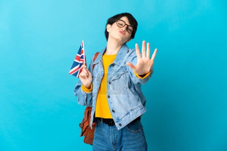 Téléchargez les photos : Femme tenant un drapeau du Royaume-Uni sur fond isolé comptant cinq avec les doigts - en image libre de droit