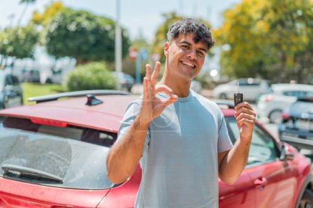 Téléchargez les photos : Jeune hispanique avec des clés de voiture montrant ok signe avec les doigts - en image libre de droit