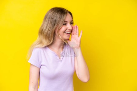 Photo for Blonde English young girl isolated on yellow background shouting with mouth wide open to the side - Royalty Free Image