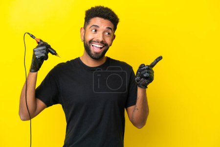 Photo for Tattoo artist man Brazilian man isolated on yellow background intending to realizes the solution while lifting a finger up - Royalty Free Image