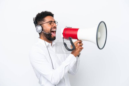 Photo for Telemarketer Brazilian man working with a headset isolated on white background shouting through a megaphone - Royalty Free Image
