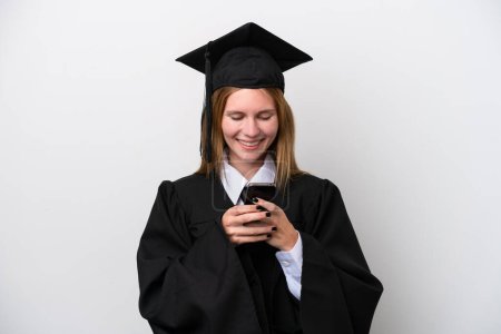 Téléchargez les photos : Jeune diplômée universitaire anglaise isolée sur fond blanc envoyant un message avec le mobile - en image libre de droit