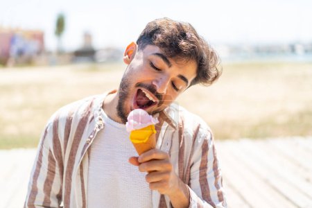 Foto de Hombre árabe guapo al aire libre con un helado de corneta - Imagen libre de derechos