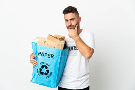 Photo for Caucasian man holding a recycling bag full of paper to recycle isolated on white background thinking - Royalty Free Image