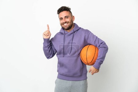 Téléchargez les photos : Basketball joueur homme isolé sur fond blanc pointant vers le haut d'une excellente idée - en image libre de droit