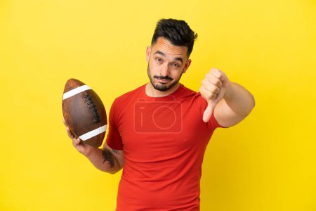 Photo for Young Caucasian man playing rugby isolated on yellow background showing thumb down with negative expression - Royalty Free Image