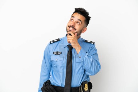 Foto de Policía caucásico hombre aislado sobre fondo blanco mirando hacia arriba mientras sonríe - Imagen libre de derechos