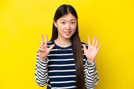 Téléchargez les photos : Jeune femme chinoise isolée sur fond jaune comptant huit doigts - en image libre de droit