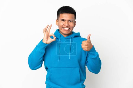Foto de Joven ecuatoriano aislado sobre fondo blanco mostrando signo y pulgar hacia arriba gesto - Imagen libre de derechos