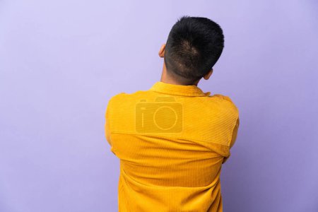 Foto de Joven ecuatoriano aislado sobre fondo púrpura en posición posterior - Imagen libre de derechos
