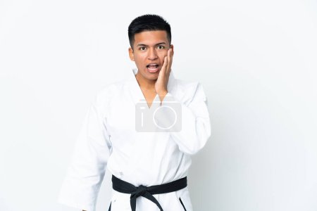 Foto de Joven ecuatoriano haciendo karate aislado sobre fondo blanco con sorpresa y expresión facial impactada - Imagen libre de derechos