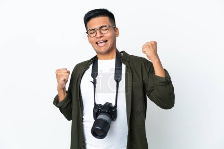 Téléchargez les photos : Jeune photographe équatorien isolé sur fond blanc célébrant une victoire - en image libre de droit