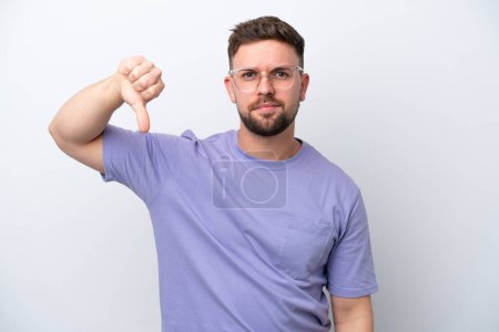 Photo for Young caucasian man isolated on white background showing thumb down with negative expression - Royalty Free Image