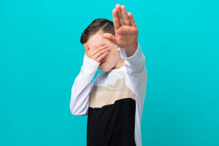Photo for Little kid boy isolated on blue background making stop gesture and covering face - Royalty Free Image