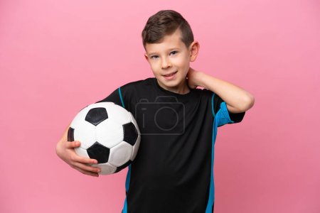 Téléchargez les photos : Petit joueur de football caucasien garçon isolé sur fond rose riant - en image libre de droit