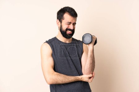 Photo for Caucasian sport man with beard making weightlifting over isolated background with pain in elbow - Royalty Free Image