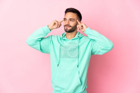 Photo for Young caucasian man isolated on pink background having doubts and thinking - Royalty Free Image