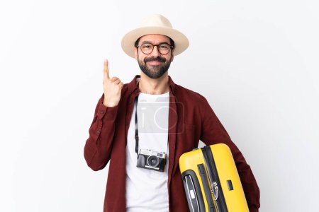 Photo for Traveler man man with beard holding a suitcase over isolated white background pointing up a great idea - Royalty Free Image