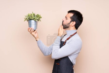 Foto de Hombre sosteniendo una planta sobre un fondo aislado - Imagen libre de derechos