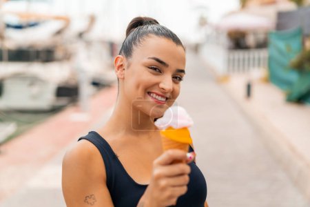 Photo for Young pretty woman with a cornet ice cream at outdoors with happy expression - Royalty Free Image