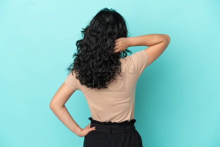 Téléchargez les photos : Jeune femme asiatique isolé sur fond bleu en position arrière et la pensée - en image libre de droit