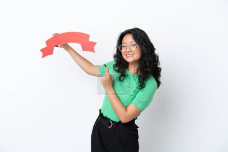 Photo for Young asian woman isolated on white background holding an empty placard and pointing it - Royalty Free Image