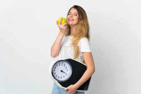 Téléchargez les photos : Jeune femme blonde isolée sur fond blanc avec peseuse et avec une pomme - en image libre de droit