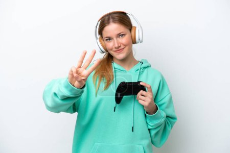 Photo for Young caucasian woman playing with a video game controller isolated on white background happy and counting three with fingers - Royalty Free Image
