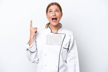 Foto de Joven chef mujer aislada sobre fondo blanco apuntando hacia arriba y sorprendida - Imagen libre de derechos