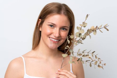 Téléchargez les photos : Jeune femme caucasienne isolée sur fond blanc tenant une branche d'eucalyptus. Gros plan portrait - en image libre de droit