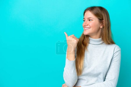 Téléchargez les photos : Jeune femme blonde isolée sur fond bleu pointant vers le côté pour présenter un produit - en image libre de droit