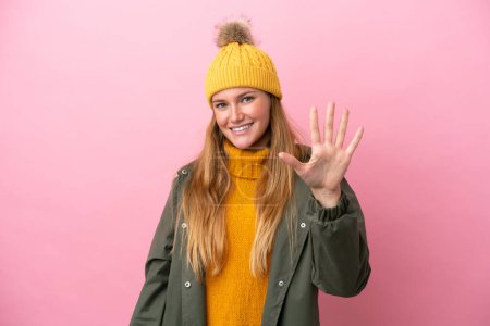 Photo for Young blonde woman wearing winter jacket isolated on pink background counting five with fingers - Royalty Free Image