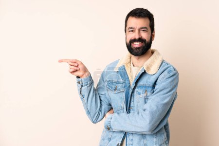 Téléchargez les photos : Homme caucasien avec barbe sur fond isolé pointant du doigt sur le côté - en image libre de droit
