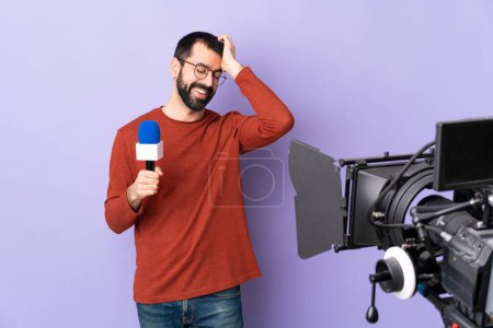 Téléchargez les photos : Reporter homme tenant un microphone et rapportant des nouvelles sur fond violet isolé riant - en image libre de droit