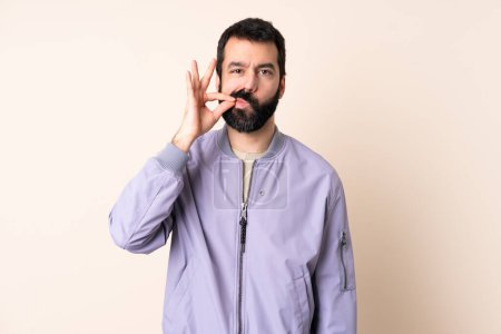 Téléchargez les photos : Homme caucasien avec barbe portant une veste sur fond isolé montrant un signe de silence geste - en image libre de droit