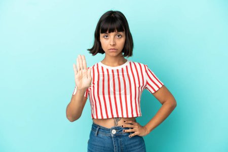Photo for Young mixed race woman isolated on blue background making stop gesture - Royalty Free Image