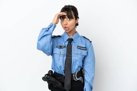 Foto de Joven policía mixta raza mujer aislado fondo haciendo gesto sorpresa mientras mira a un lado - Imagen libre de derechos