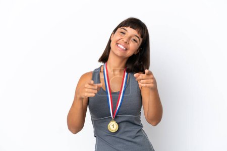 Photo for Young mixed race woman with medals isolated on white background points finger at you while smiling - Royalty Free Image